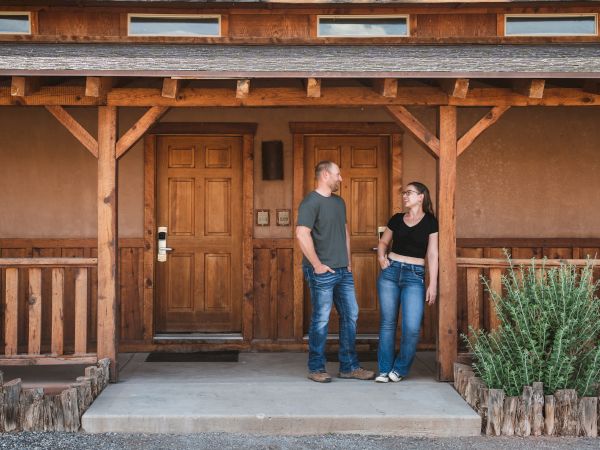 A couple talks on the porch of their hotel room
