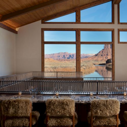 A rustic kitchen or bar area with a wooden counter, warm lighting, exposed beams, and a window view of a snowy outdoor scene, cozy vibe.