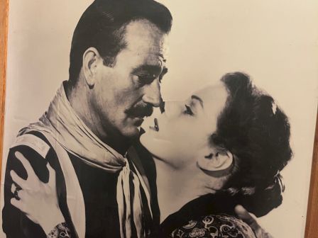 A vintage black-and-white photo of a couple gazing into each other&rsquo;s eyes, embracing warmly as if in a tender moment.